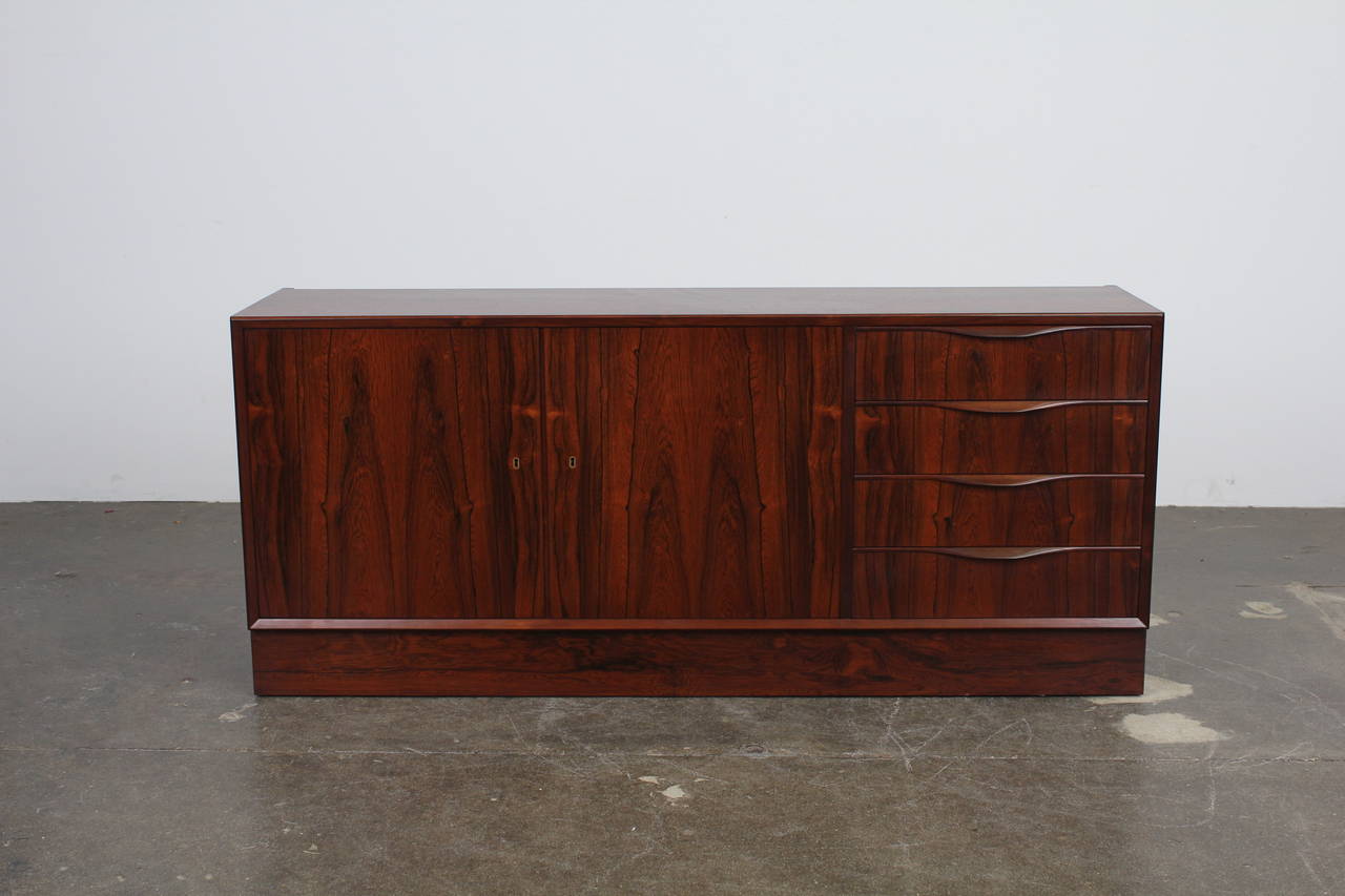 Beautiful Danish Mid-Century Modern 2 door, 4 drawer Rosewood Sideboard designed by Erling Torvits. Book matched grain through the drawers and 2 doors, incredibly strong grain.  Plinth base can be replaced with a tapering leg base at slight extra