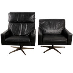 Pair of black leather Danish mid century modern swivel chairs.