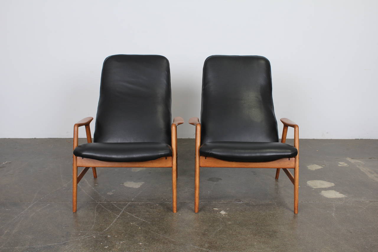 Beautiful pair of Kontur reclining chairs by Alf Svensson, newly upholstered in black leather. Designed in 1957 for DUX, with a solid beech frame that has been fully refinished in lacquer.