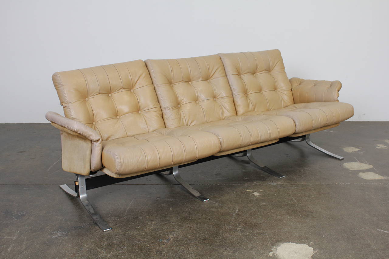Danish Mid-Century Modern three-seat tufted leather and metal framed sofa by Ebbe Gehl & Søren Nissen. Model Atlantis produced by Jeki Møbler. Flat bar metal frame with suede cushion supports. Beautiful patina on the leather throughout.