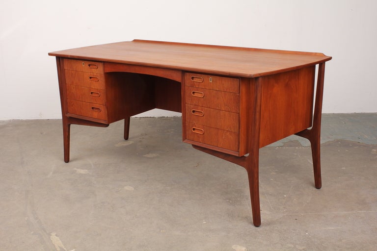 Danish mid century modern 8 drawer executive desk by Svend Aage Madsen, produced by H.P. Hansen. Beautiful teak grain, back storage and locking cabinet highlight this superb desk.