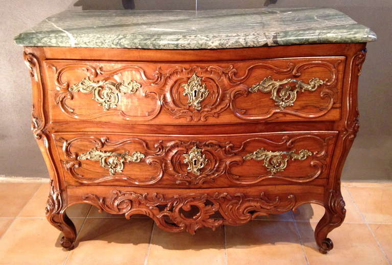 Exceptional commode two drawers in solid walnut.
 Model all curved surfaces and cross girders rock in the front and on the sides.
The amounts to double staple acanthus terminated feet snails very purpose. 
Richly decorated with gilt bronze with
