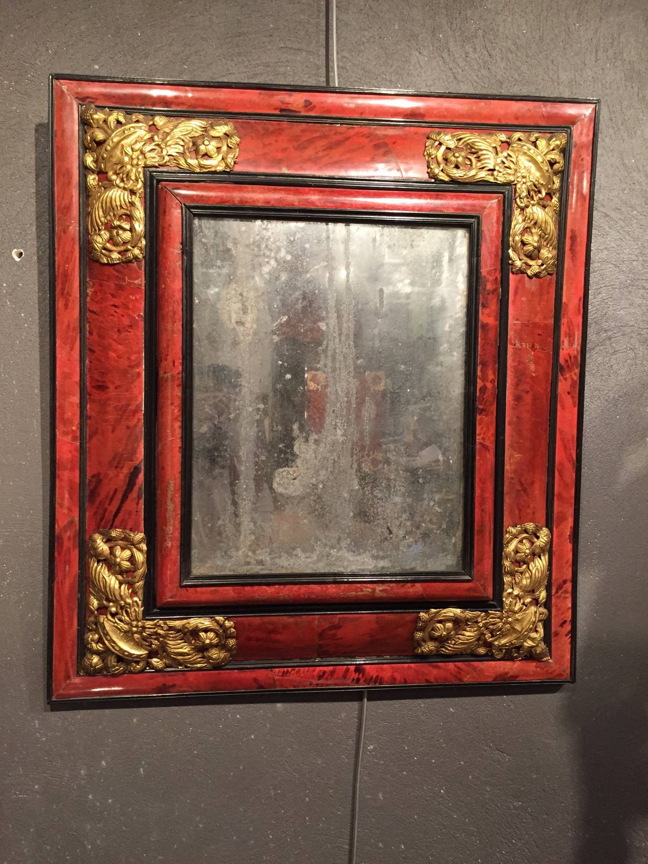 Flemish 17th century red tortoiseshell mirror
Rare double inverted mirror frames profiles.
Model in red tortoiseshell veneer (green turtle), ebony and copper rods carved spandrels and repelled decorated with foliage flowers.

Soul tree.

Glass