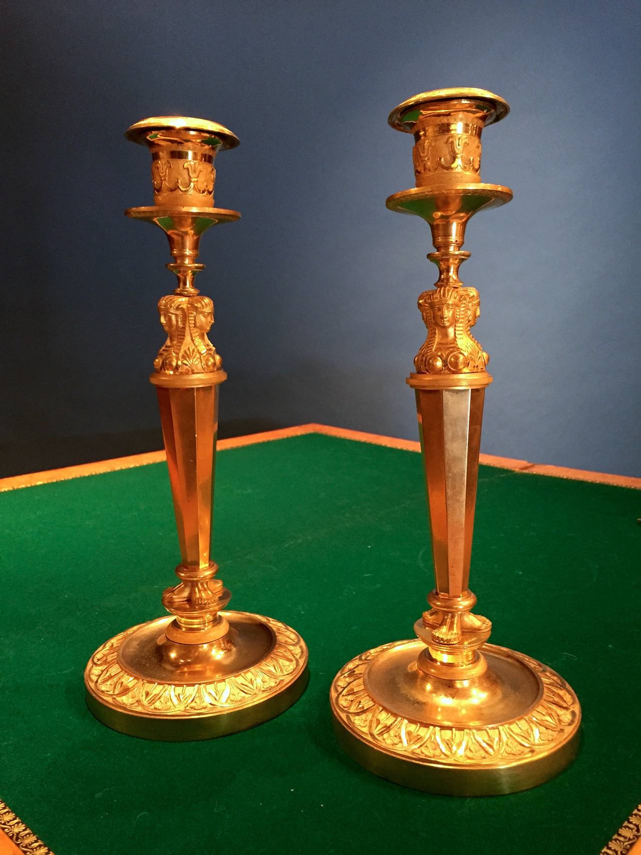 Pair of pharaohs candlesticks, Paris Empire period.

Bronze finely carved and gilded, the six drums matte gilt-framed supporting three female heads capped Nemes (headdress of the pharaohs) and ending with three pairs of bare feet.
The binets,