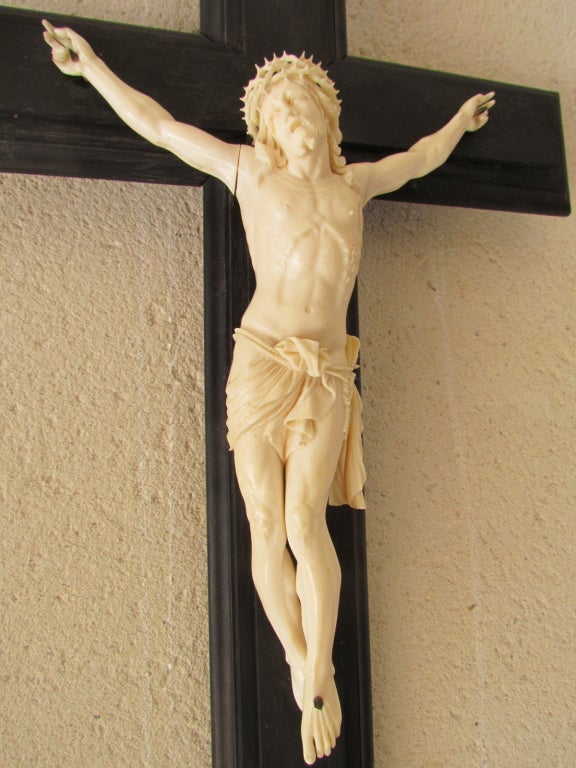 Rare crucifixen ivory in ebony on his cross. The excavated from the crown of thorns and hair, the overview of the rib cage, bloody wounds and painful facial expression make this a piece exeptionnelle christ. The perizonium is tied by a cord very