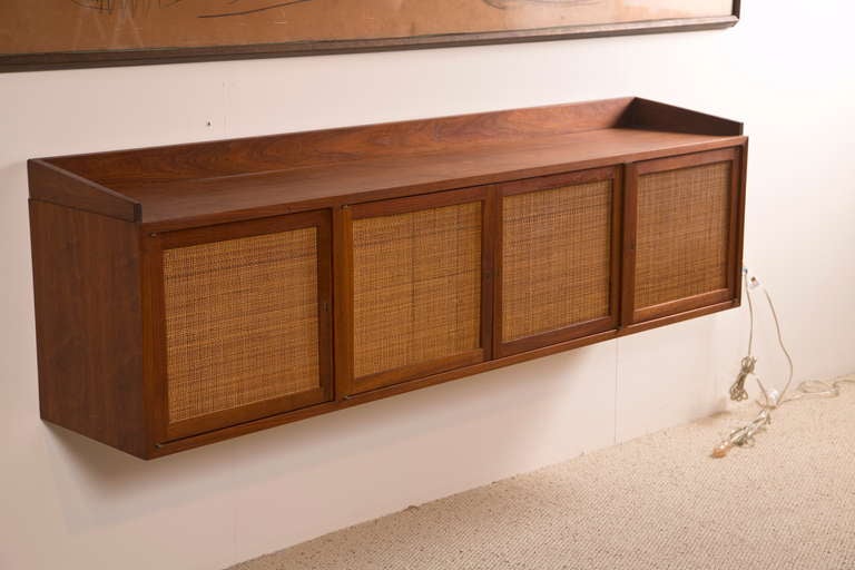 Lovely credenza, wall mounted with bolts. Cane front is in perfect condition. The only defect are some scratches to the left side which we can restore for an additional cost. We do not have the original keys to the piece but we may be able to quire