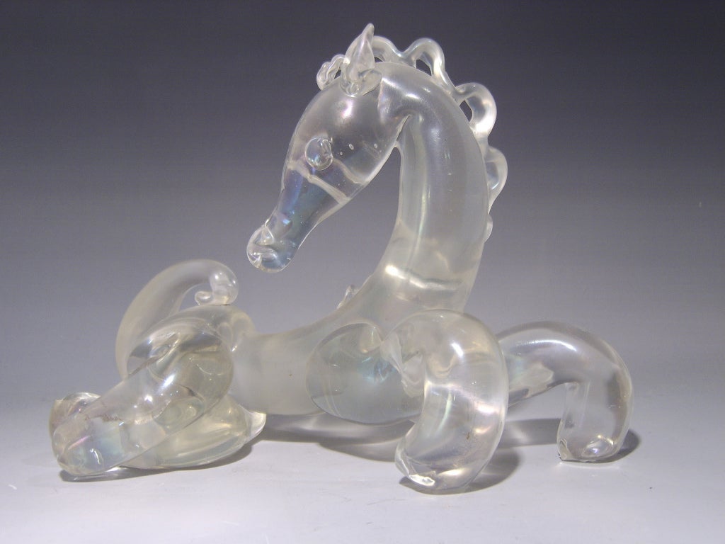 A figure of a stylised horse in hand worked clear glass with an overall irridescent finish by Archimede Seguso.