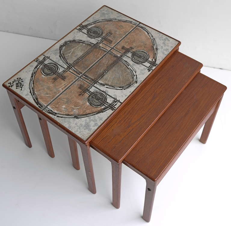 Danish teak nesting tables by Oxart.

Ceramic art tiles laid on top of the largest table.