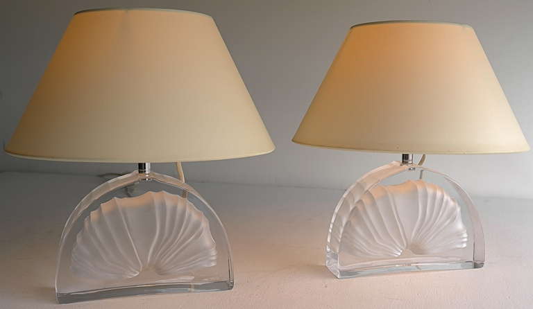 Pair of table lamps by Daum France
Crystal lamp base of semi-circular form, with frosted glass fossil design. 
Signed 'Daum France

Height 34cm, diameter hood 29cm