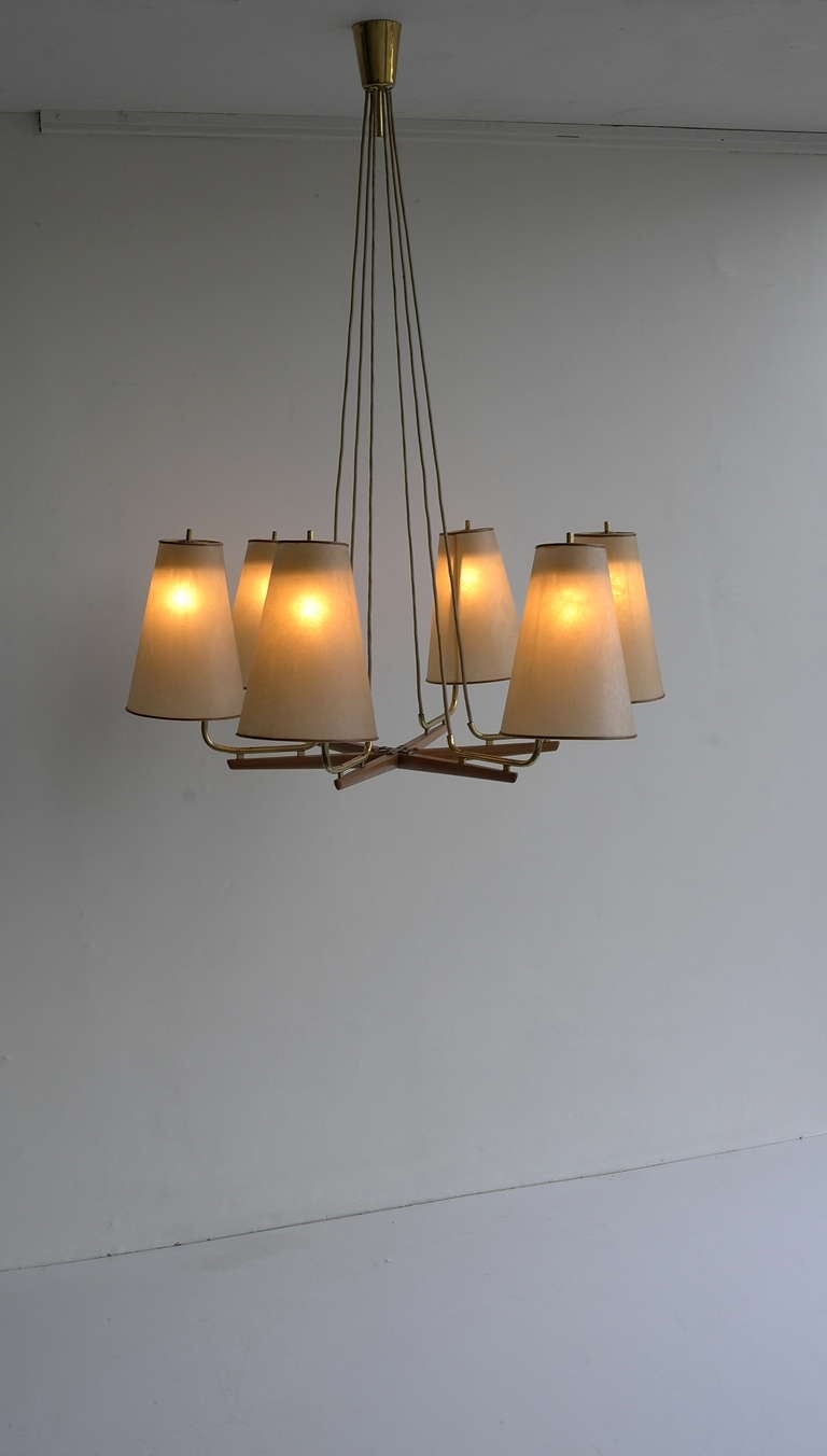 J.T. Kalmar chandelier 1950's.

This lamp has got six bladder shades with a fine leather finish.
The wooden base and brass tubes are subtly.

Total height 100cm but adjustable.
The diameter is 83cm
Each shade is 25cm in height, diameter