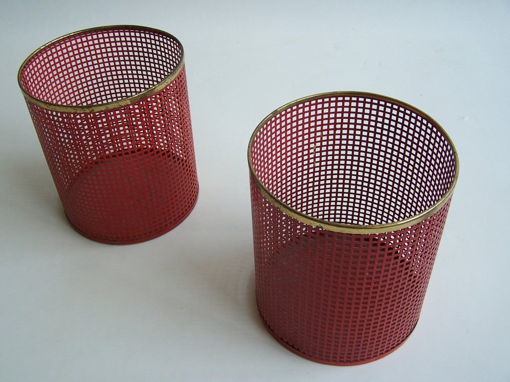 A pair of metal waste paper baskets, red metal with brass ring.
By Artimeta Soest The Netherlands 1950's.