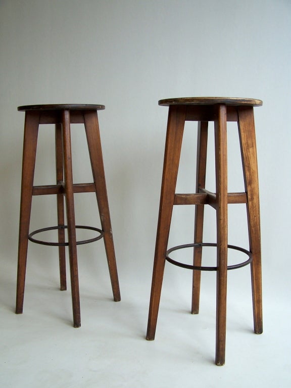Pair of French stools from the 1950's.
Wooden frame and seating, metal footrest.

Sold together, Each 80cm in height, diameter 33cm.