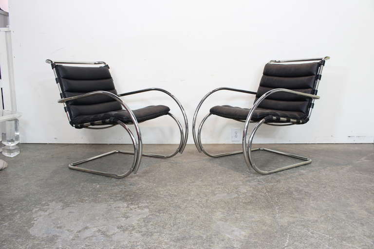 MR. lounge chairs by Mies Van Der Rohe for Knoll.
These chairs have a chrome base with leather straps that support the black leather cushion. dimensions: 25.5