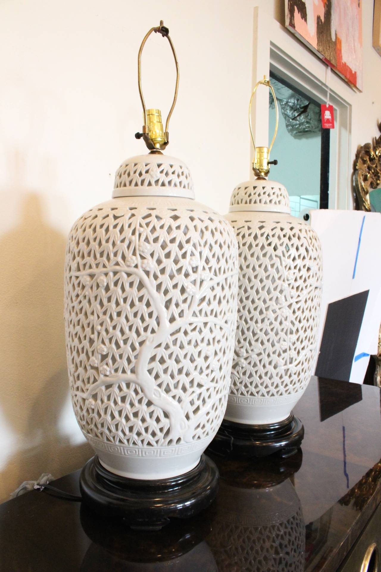 Pair of monumental porcelain Blanc de Chine pierced table lamps. Dark stainwood base, circa 1960s. 

Dimensions: 12