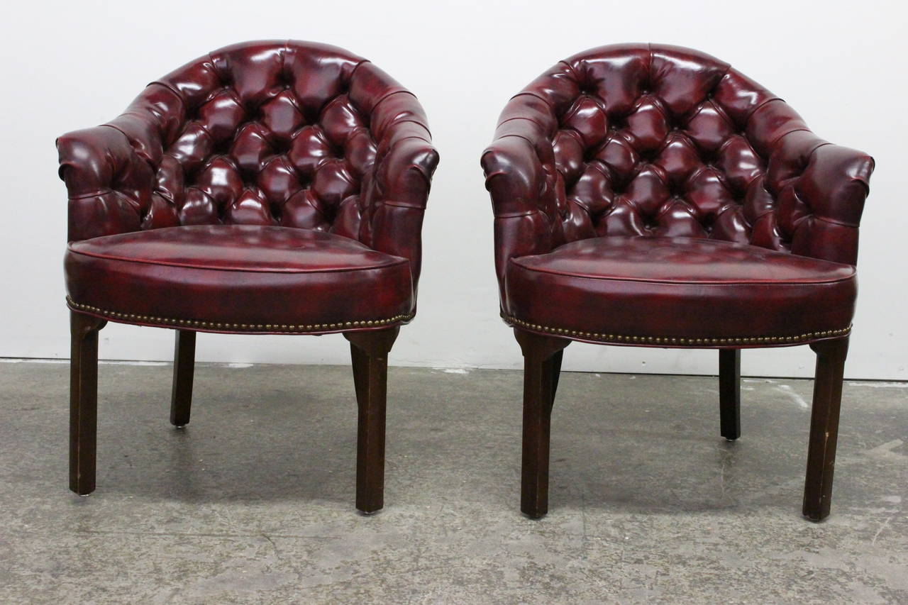 Pair of oxblood tufted armchairs. Trimmed with brass nailheads, circa 1970s. 

Dimensions: 28