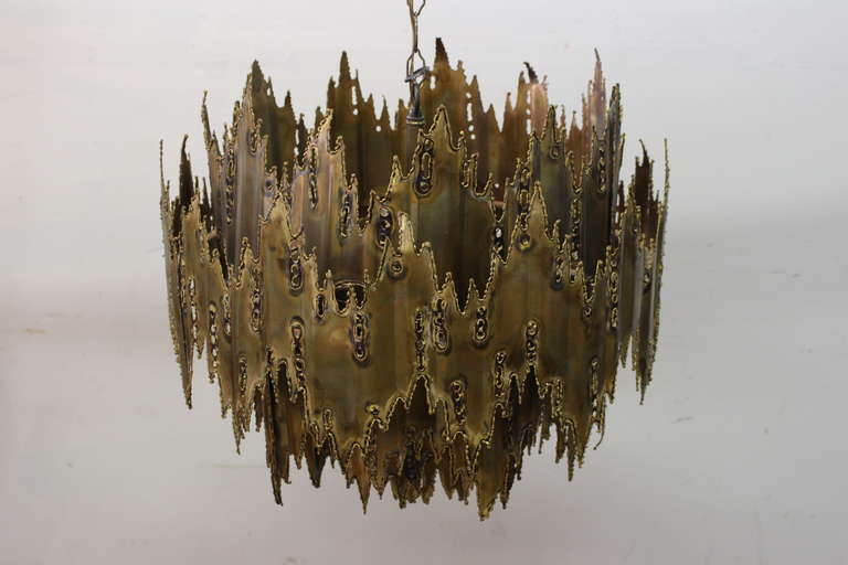 Hand crafted torch cut and patinaed brass chandelier by Tom Green.Consists of six lights and one center down light.