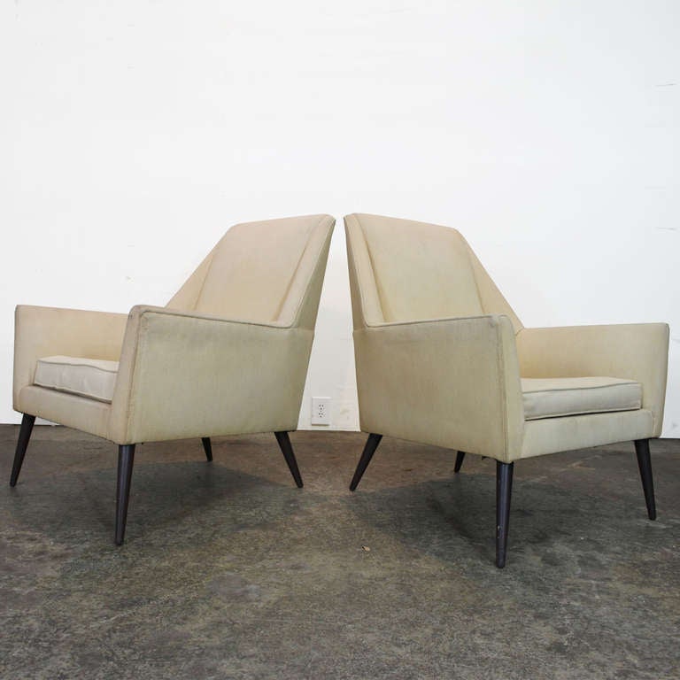 Rare pair angular lounge chairs by Paul McCobb. These sculptural chairs have a high back with conical wood legs.

For your convenience we offer in-house upholstery service and you can have the fabric shipped to us. Contact us for quotes.