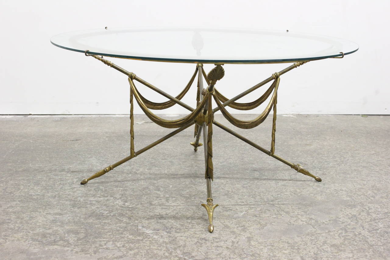 Gueridon style brass arrow coffee table. 36 inch round glass table top, circa 1970s

Dimensions: 36