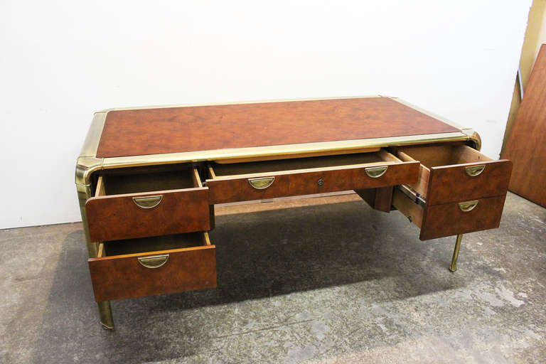 Very handsome burl and brass executive desk by John Widdicomb. Four drawers in total with one large drawer for hanging files. The desk is finished on all sides with burl and brass with inset drawer pulls. dimensions are 72