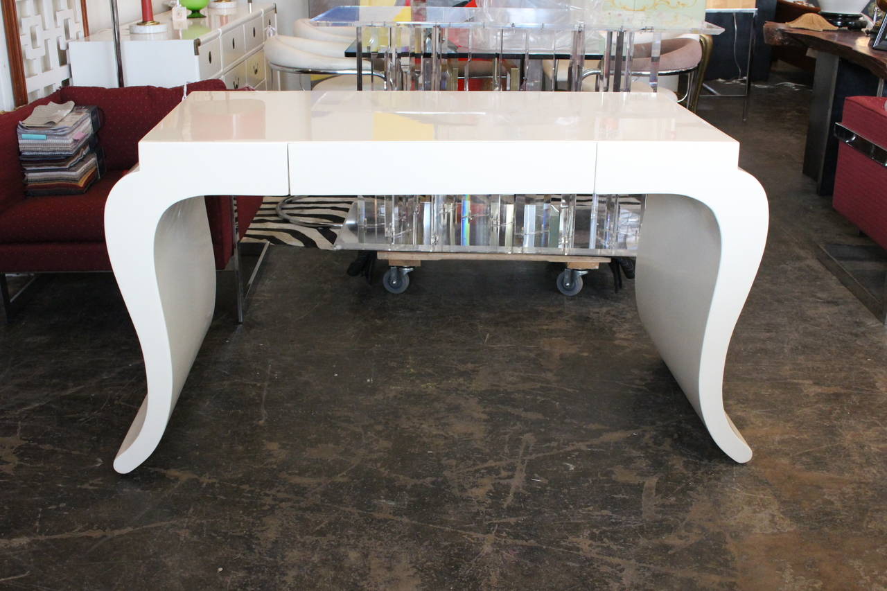 This glamorous curvaceous desk has a new lacquer finish in an alabaster gloss. There is a single drawer for storage, circa 1980s.

Dimensions: 54