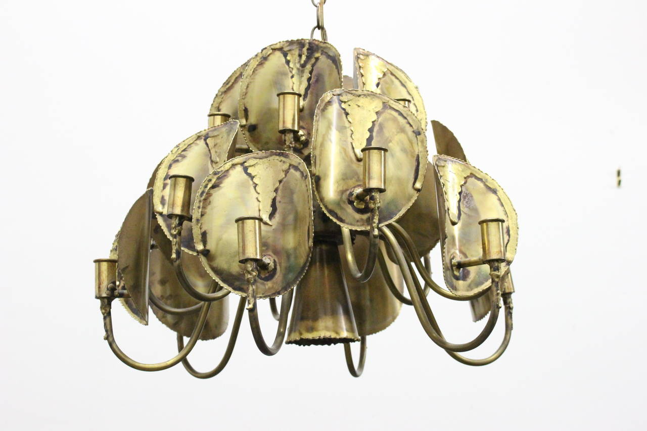 Brass brutalist chandelier by Tom Green for Feldman. Nineteen lights with one down facing light. No escutcheon plate, circa 1970s.

Dimensions: 21.5