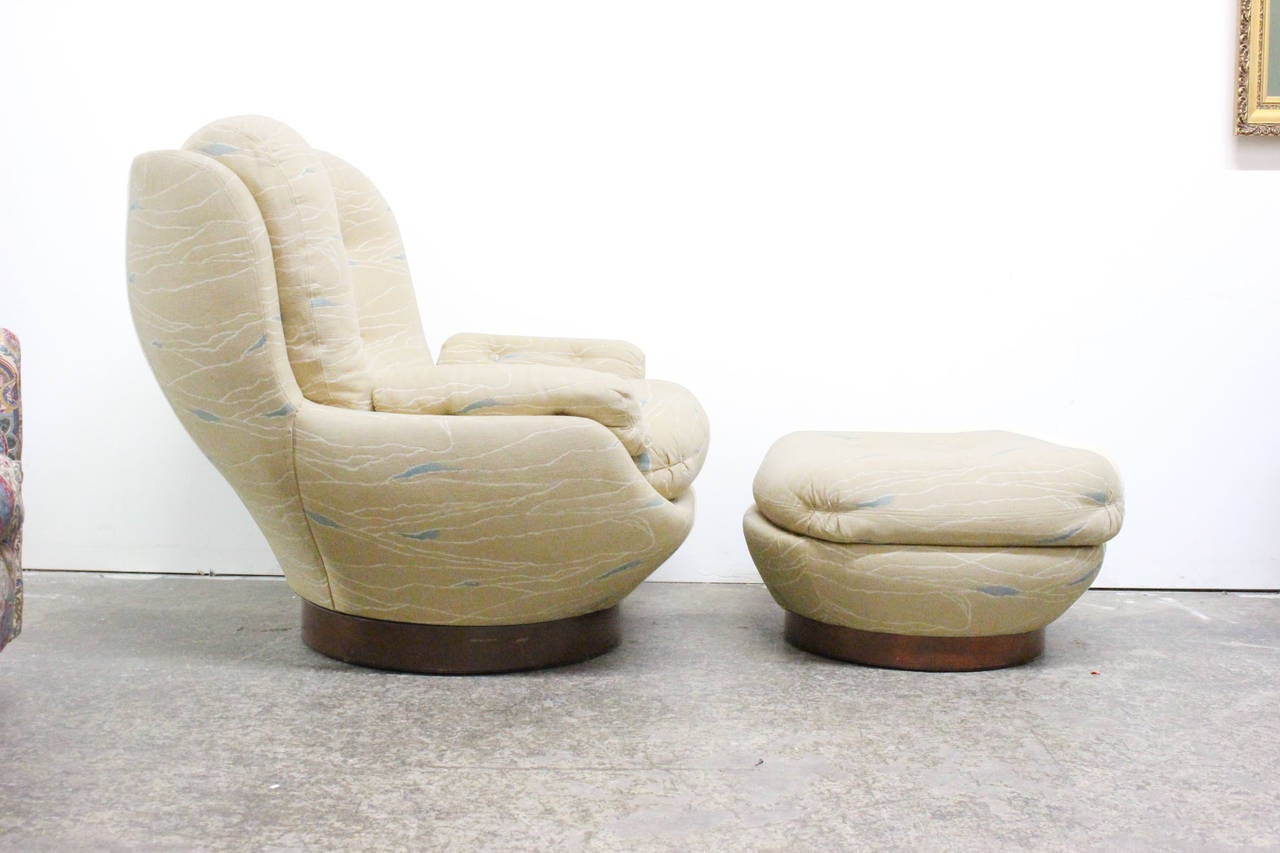 Swivel lounge chairs and ottoman. Wood veneered plinth base, circa 1970s.

Dimensions: 37