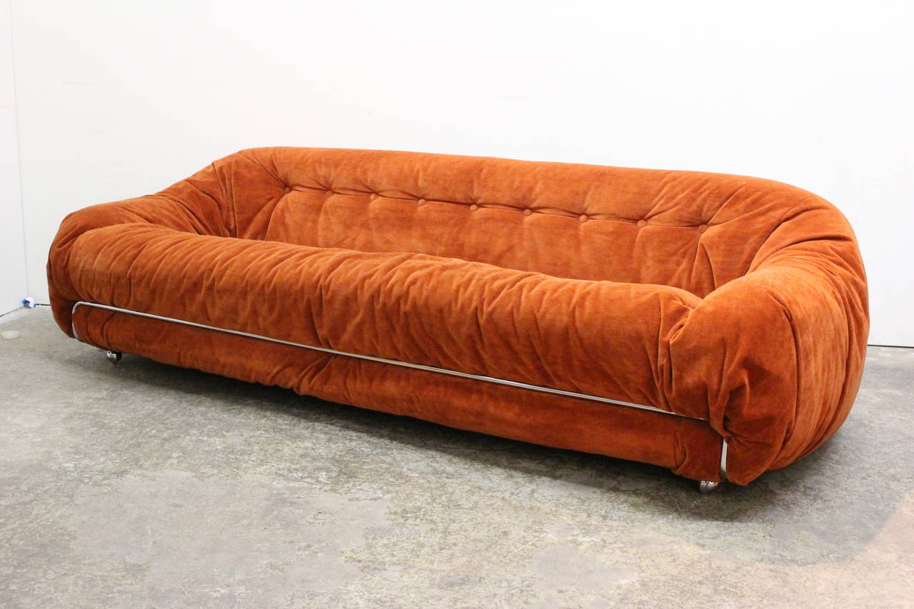 Groovy orange velvet sofa in the style of Tobia Scarpa. Sofa is upholstered in an informal way of folding and gathering. Chrome accents and on casters,
circa 1970s.

Dimensions: 84