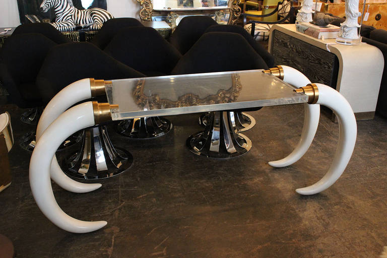 Faux elephant tusk lucite table with brass accents designed by Suzanne Dahl & Jerry Barich. The lucite table top rests inside the brackets and gives the illusion of a floating table top. Perfect for entry or can be used as a writing desk.