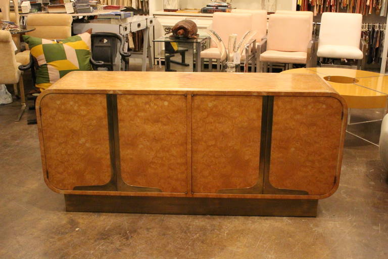 Mastercraft credenza in burl wood and brass accents. There is brass inlay on top and on the side of credenza. 

There is some areas of the credenza the wood has faded to a lighter color.