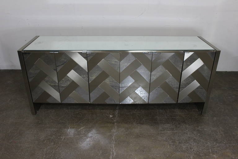 Herringbone pattern in polished and satin chrome. Six-door panels open and reveal a set of three drawers in both sections of case piece. There is some surface abrasions on chrome and small indentations around perimeter. There are also some