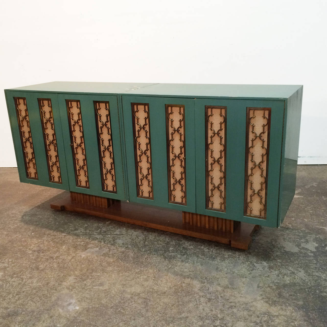 Four paneled door credenza by Renzo Rutili. Doors have metal fret work backed with fabric covered panels. The credenza does need to be refinished and is in overall good condition. 

Dimensions: 66.5