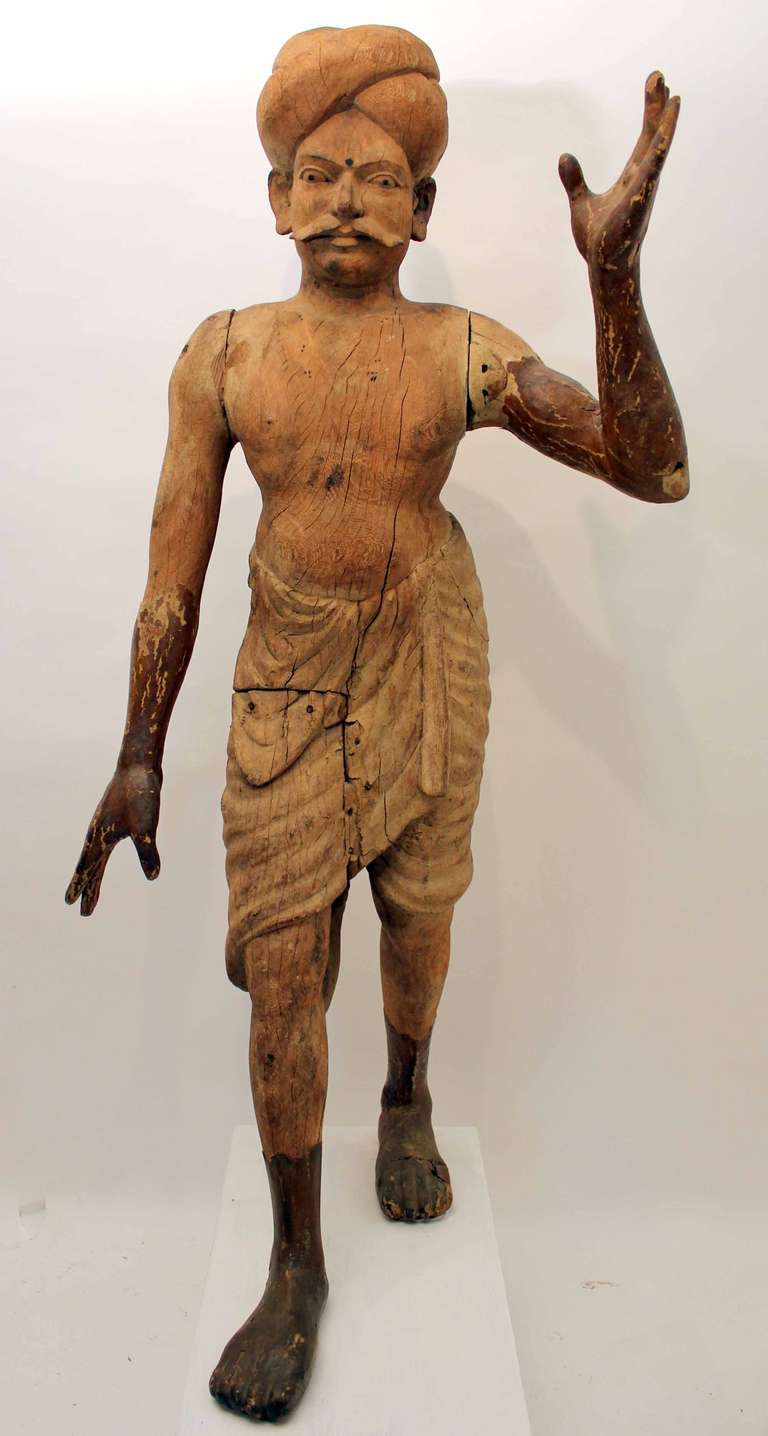A really wonderful early 19th century carved figure of a Indian walla or Brahman.  Carved from a Indian hard wood, traces of original gesso and paint work.  Mounted on a contemporary base.