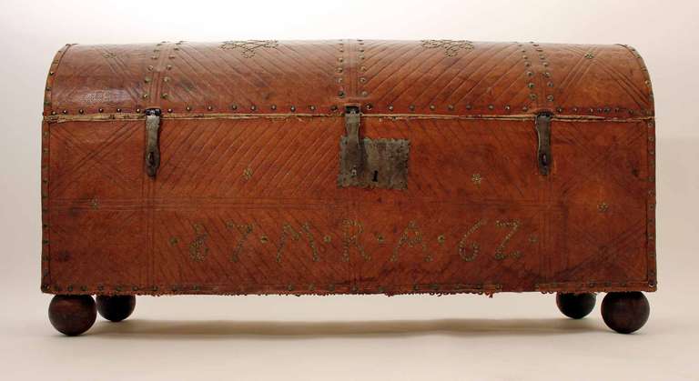 A beautifully embellished 19th century trunk with embossed leather and patterned interior. With hinged lid and natural patina.