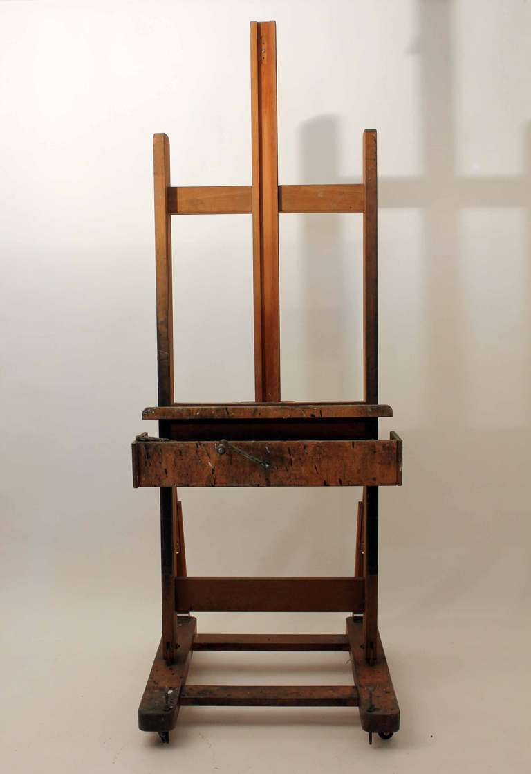 A large scale easel in good working order, comprising of adjustable angles and a large extender which can adjust to over three meters, the easel has two draws built in on each end plus a winding handle.