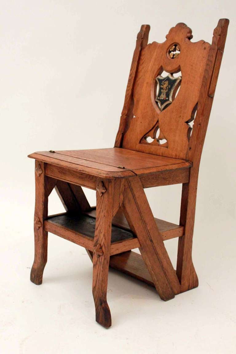 A 19th century oak gothic revival metamorphic library chair which fold into a set of steps with family crest on back shield in good condition.