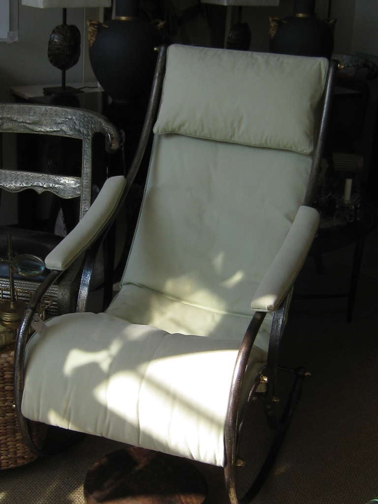 19th century English cast iron chair attributed to Robert Winfield having white canvas upholstery. The chair has all the accoutrements expected with Campaign furniture of its era; including the brass bolts that were used to disassemble the chair for