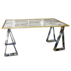 French polished steel and brass saw horse base and glass top