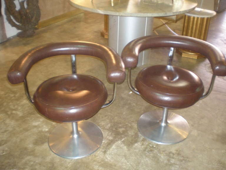 A pair of brown leather and chrome swivel chairs by ICF Finland