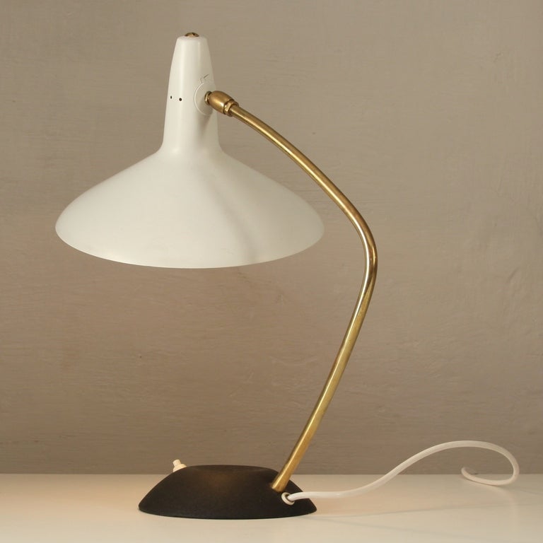Nice fifties tablelamp.Brass arm and black metal feet,white laquered metal shade.The shade can be orientated.

These are hard to find tablelamps,in fantastic condition and very decorative.Wiring tested.

All Original.
