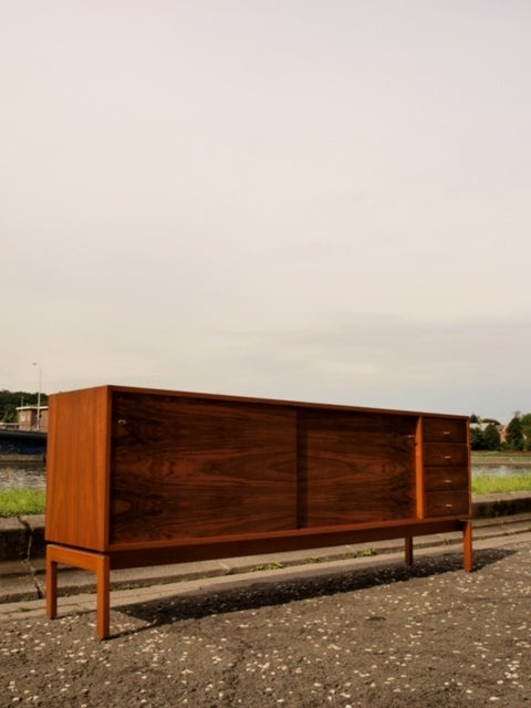 High quality sideboard from the 'Abstrakta' series (1960), finished  in natural wallnutveneer designed by Jos De Mey.

4  drawers and 2 sliding doors with shelving  compartements  for optimal storage.Copper handles and bras feet to adjust the