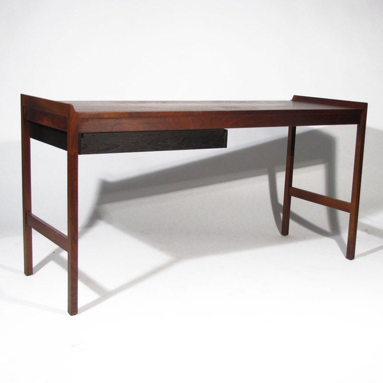 Minimalist American walnut desk with single black drawer. Attractive walnut figuring and color. Raised side borders with pencil detail.  This piece could also serve as a nice hall or entrance table.

Overall excellent restored condition. Fully