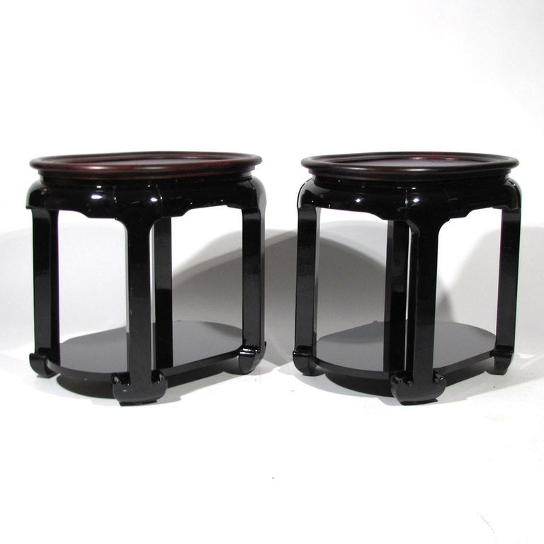 Pair Chinese oval form end tables comprised of inlay exotic wood tray tops resting on black lacquer bases.Tray tops easily lift off, but are kept in stationary position when resting on bases by a very small lower skirt. Surface under tops is black