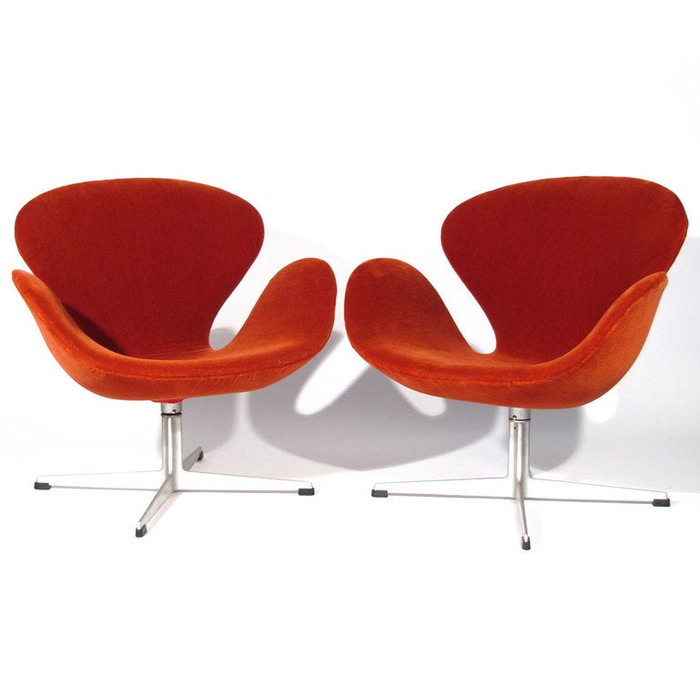 Trio iconic Arne Jacobsen for Fritz Hansen swan chairs. Swivel chair rests on cast aluminum base. Early model newly upholstered in blood orange velvet. 

Overall excellent condition. New upholstery. Bases free of issue.