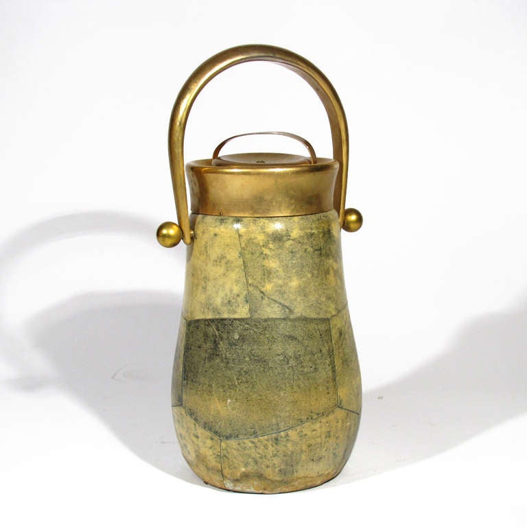 Colossal ice bucket in shades of greens and golds on goat skin designed by Aldo Tura. Hammered brass handle and top with thick cork insert. Silver lined glass interior.

Excellent condition.