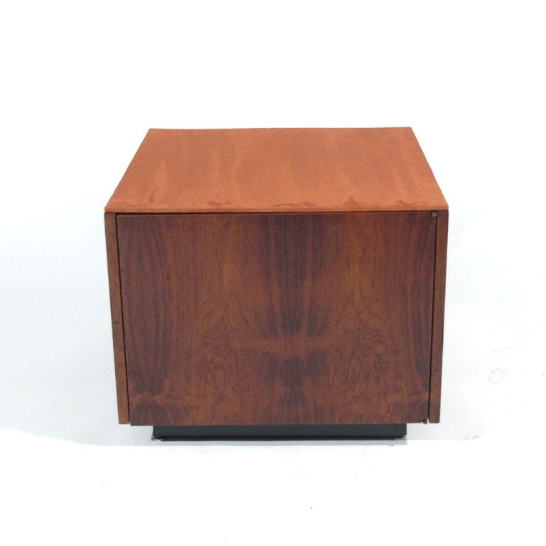 Unusual Danish rosewood cube form stool or table with a generous storage compartment beneath a newly upholstered blush suede top. It would be very easy to upholster the top with a cushion etc. Dramatic rosewood figuring on all four sides supported