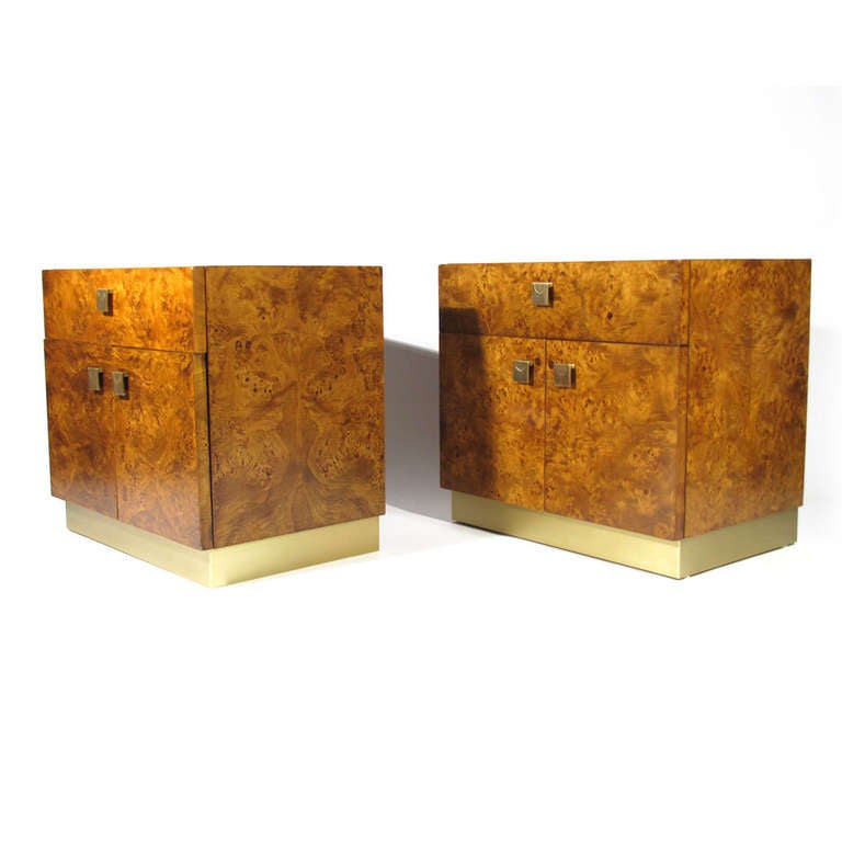 Beautiful pair burl nightstands with satin brass pulls and base. Exceptional color and detail in burl olive wood, which is also present throughout interior. Single drawer above two doors revealing larger storage compartment. Immaculate restored