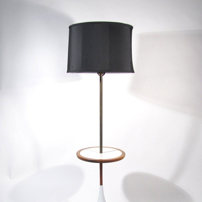An unusual Saarinen Laurel era floor table lamp with heavy weighted tulip base bottom, walnut lower stem and border, white laminate table top, and patinated brass top stem.

Pristine restored condition.