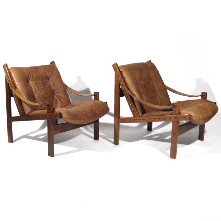 Handsome pair Trobjorn Afdal club chairs. Tufted soft mocha leather seats supported by rope and canvas, with the rope coursing in and out of frame, along with leather sling arms. Beautiful color and figuring to jacaranda wood. Exceedingly