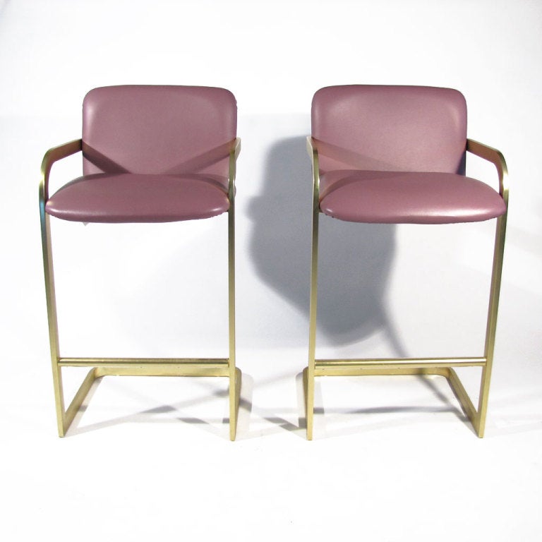 Attractive pair DIA cantilever bar stools upholstered in light plum leatherette.Satin brass plate over aluminum. DIA labels affixed to undersides. Very comfortable.
