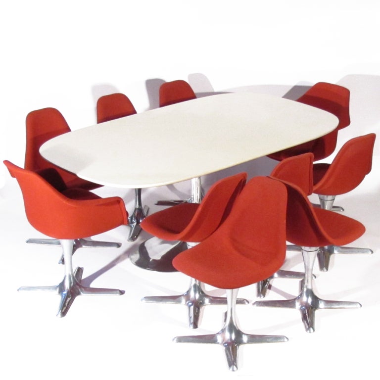 Stellar mod Chromcraft dining set of consisting of 8 side chairs, 2 arm chairs, and a large rounded edge rectangular table. Chairs upholstered in soft red woven wool, bases polished aluminum. All chairs swivel with ease. Table with off white gloss